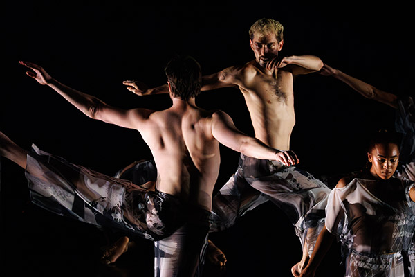 Trisha Brown Dance Company performing on a dark stage