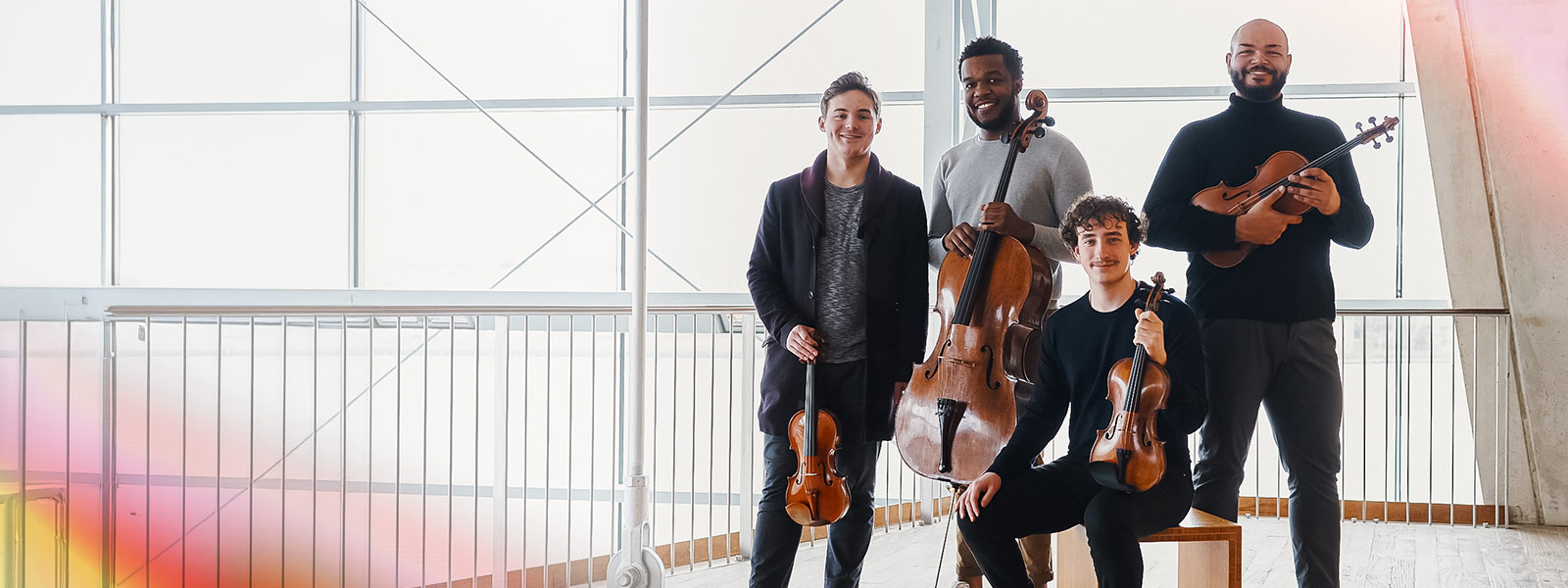 Isidore String Quartet smiling at the camera holding their instruments