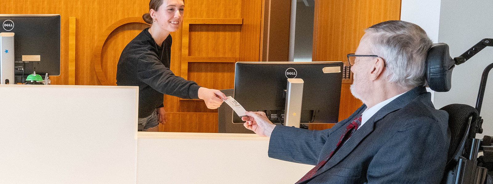 Box office cashier handing a ticket to a patron