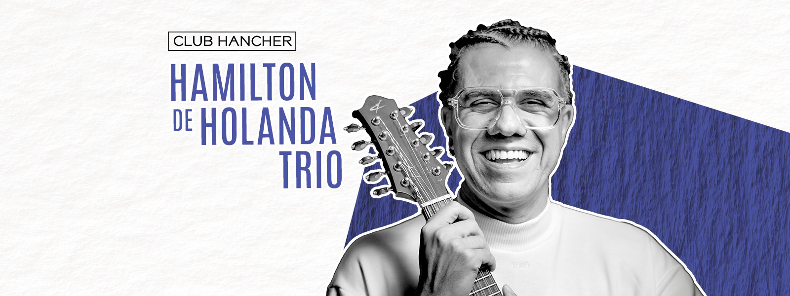 Black and white portrait of Hamilton de Holanda smiling while holding a bandolin