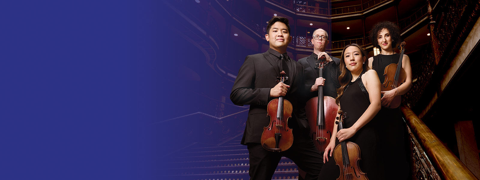 Verona Quartet posing with their instruments in an auditorium