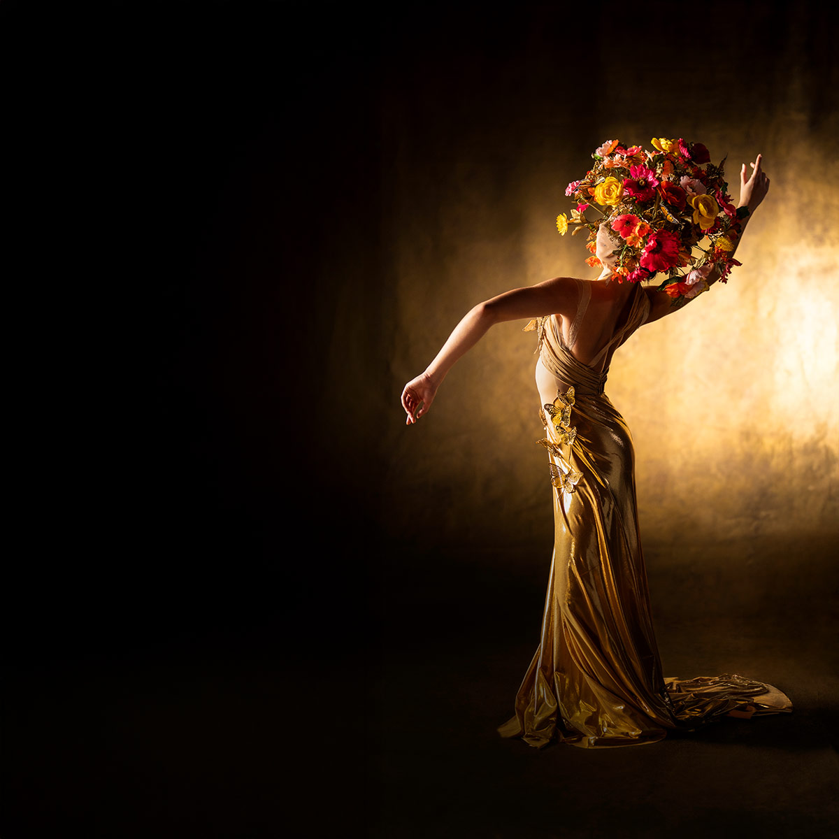 A Ballet Hispánico dancer standing with flowing arms wearing a large crown of flowers