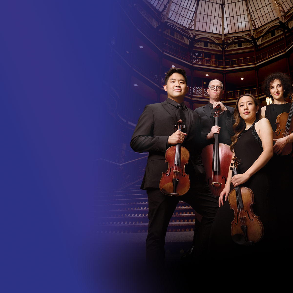 Verona Quartet posing with their instruments in an auditorium
