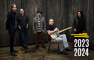Jason Isbell sitting in a chair with his guitar surrounded by the 400 unit