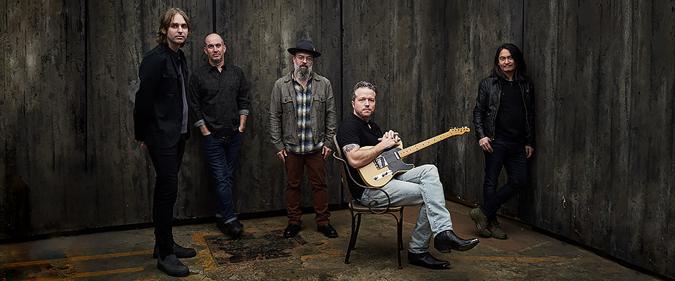 Jason Isbell sitting in a chair with his guitar surrounded by the 400 unit