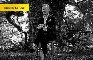 Black and white photo of Lyle Lovett sitting in chair in front of a large tree with Added Show gold text box in upper left 