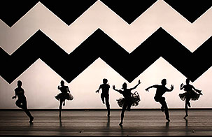 Dancers from American Ballet Theatre dance in silhouette against a background with a giant zig-zag pattern