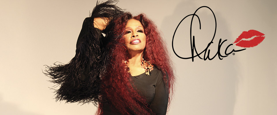 Chaka Khan in a black dress with her signature "Chaka" with a red lip imprint against a beige background. 