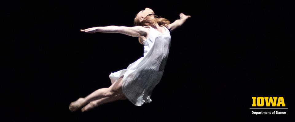 A solo dancer is photographed in mid-leap