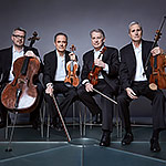 The musicians of the Emerson String Quartet sit with their instruments