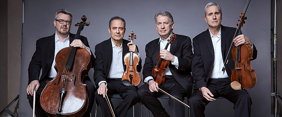 The musicians of the Emerson String Quartet sit with their instruments