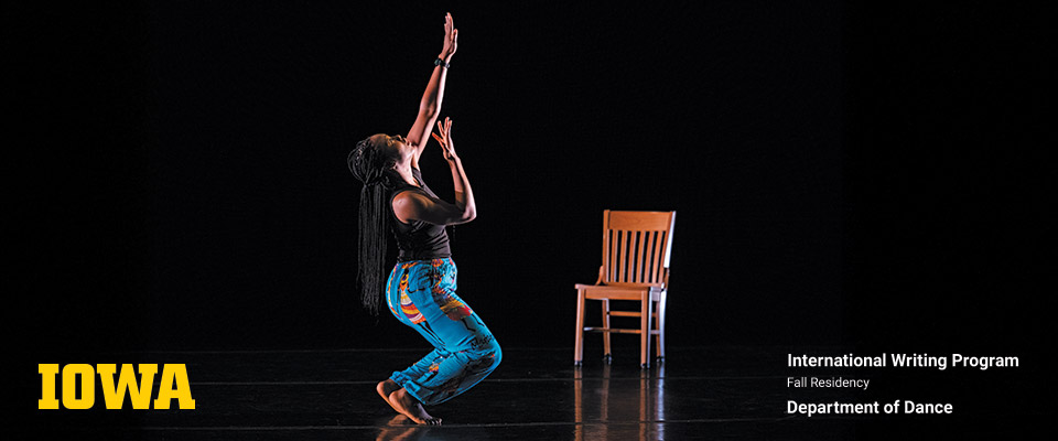 UI dancer on stage in a movement next to a chair