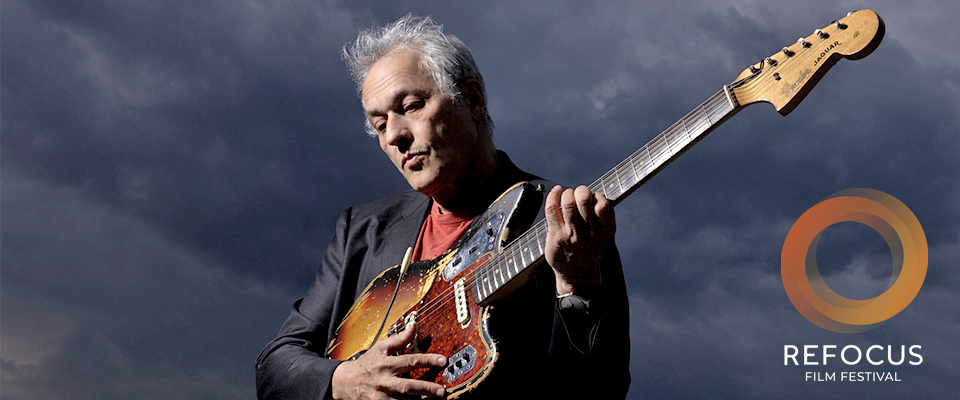 Marc Ribot playing guitar against a grey background. Refocus Fillm Festival logo in lower right corner