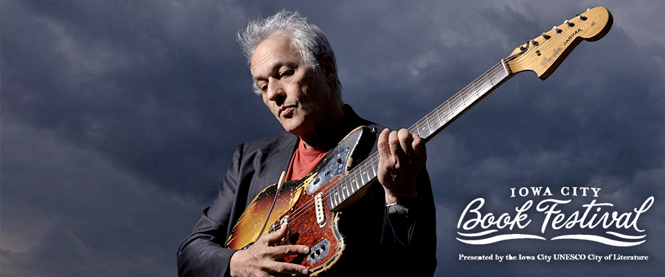 Marc Ribot playing guitar against a grey background. Iowa City Book Festival logo in lower right corner