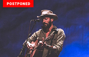 Ray LaMontagne Trouble 20th Anniversary Tour Ray LaMontagne on stage playing a guitar. Upper left corner has text box that says postponed to September 2026