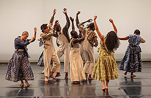 Fist and Heel Performance group dancing on stage in muted wardrobe colors