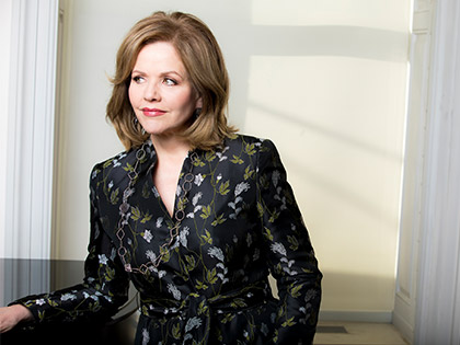 Renée Fleming leaning against a windowsill