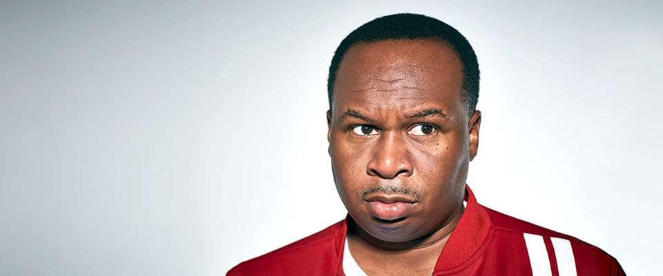 Roy Wood Jr. in a red track jacket, looking perturbed