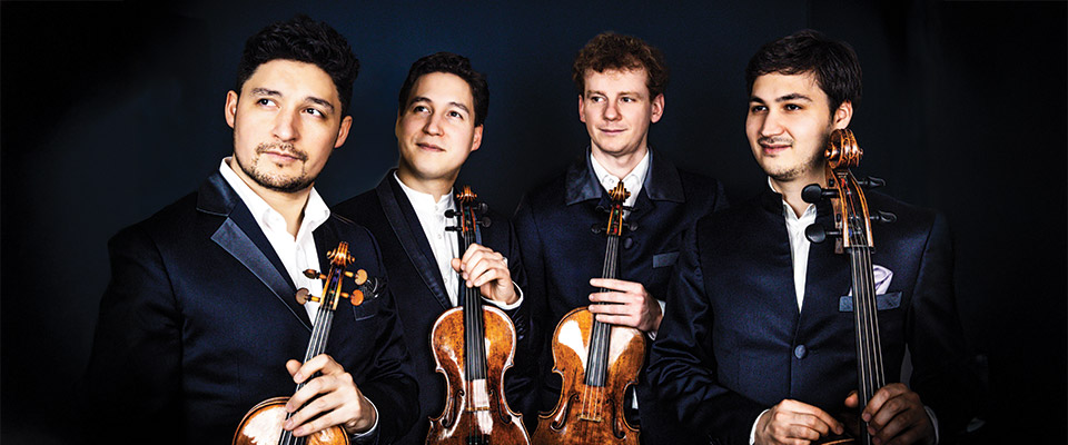 Four members of the Schumann Quartet against a black background