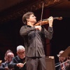 Joshua Bell playing while standing in the middle of an ensemble sitting down and playing string instruments