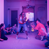 Dancers performing in a house atmosphere under a pink light with text "Performing Arts At Iowa 25-26)