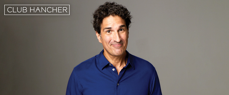 Gary Gulman weaking blue button down close-lipped smiling straight on at the camera. Club Hancher text treatment in upper left corner