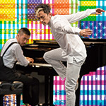 Conrad Tao playing piano and Caleb Teicher dancing against Hancher's Infinite Dream flag treatment