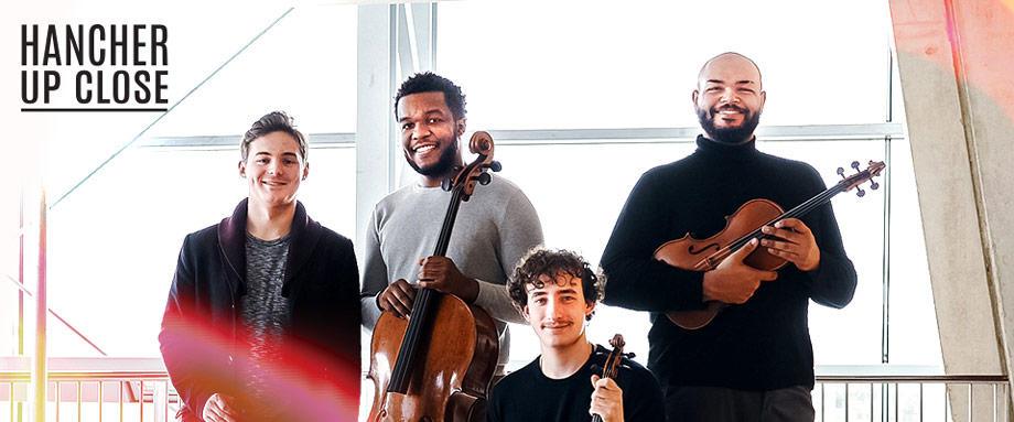 Isidore String Quartet Isidore String Quartet standing looking at the camera while holding their insturments