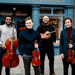 Isidore String Quartet standing looking at the camera while holding their instruments