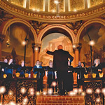 The Crossing Music Director Donald Nally with his back to the camera in motion conducting standing choir 